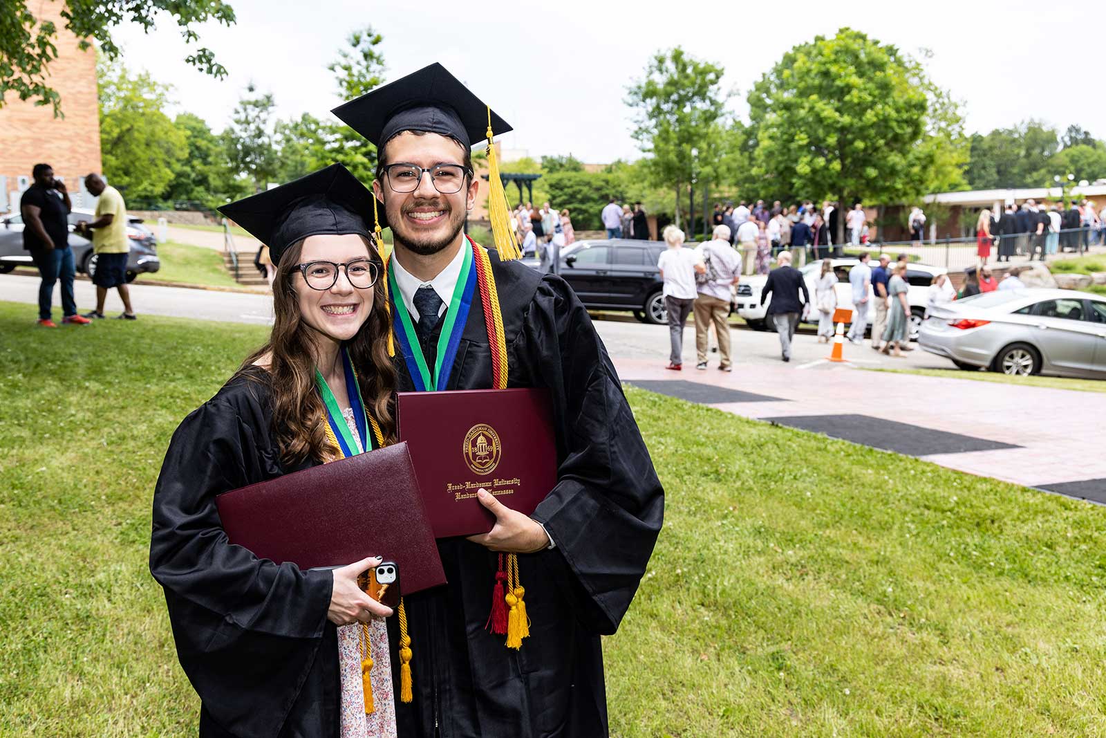 two students at commencement outside