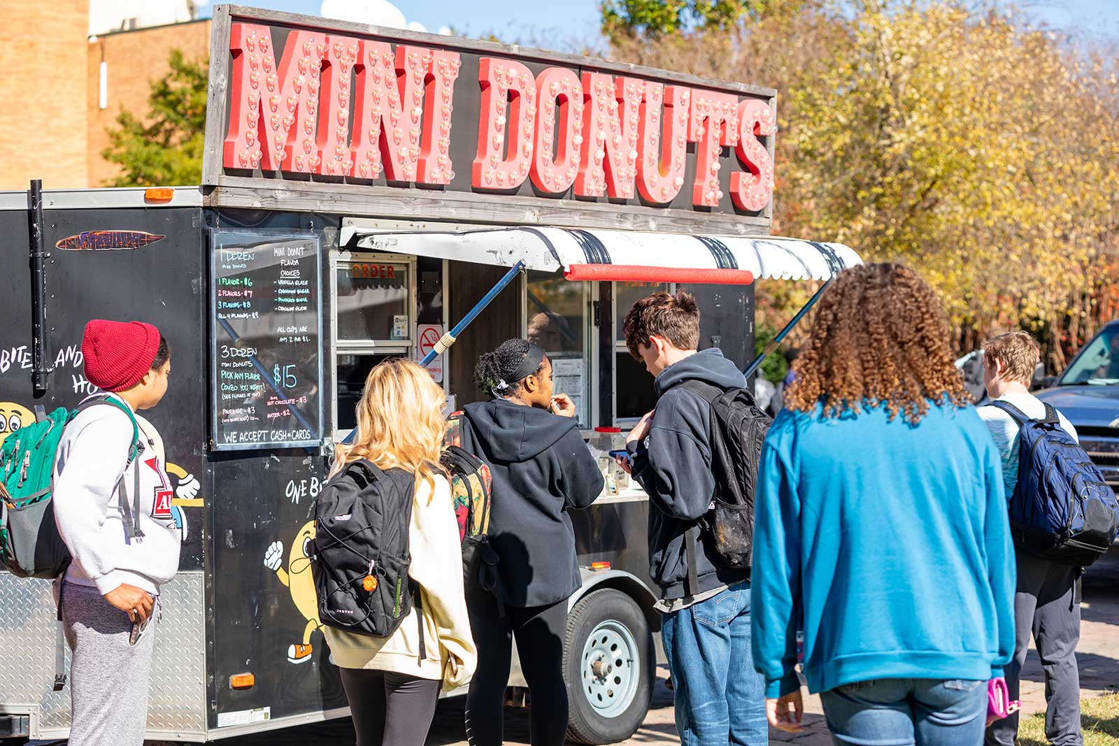 students outside a mini donuts food truck