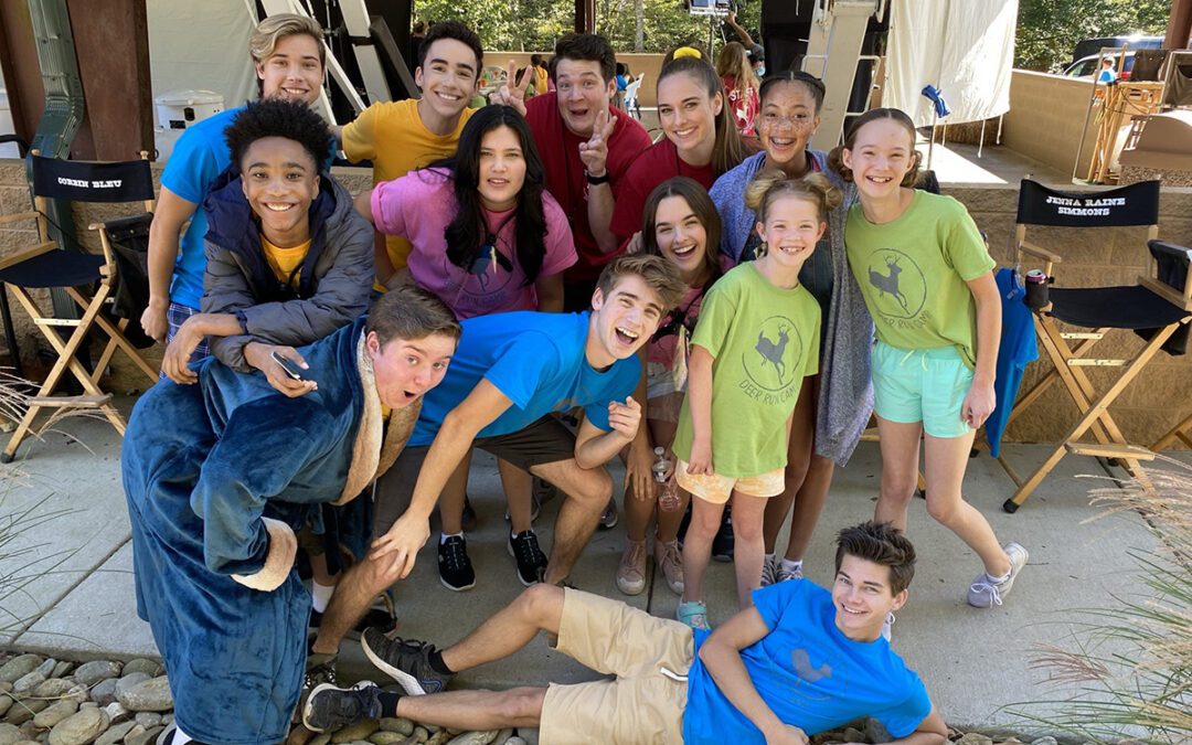 The cast of "Camp Hideout" take a group photo. Brown is laying on the ground.
