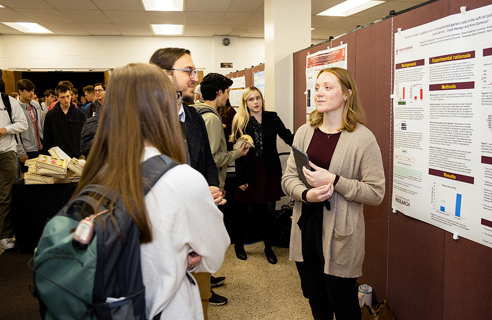 FHU senior, biology major Josie Gannon discusses her poster presentation titled “Into the Unknown: Updates on an Uncharacterized Gene’s Role in the Soft Rot Pathogen Pectobacterium Versatile.”