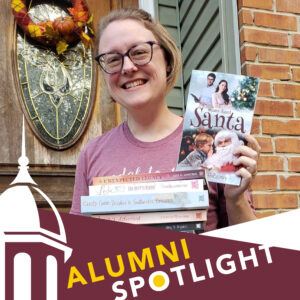 A smiling woman stands at a front door holding several romance novels, including one titled Mama Dated Santa. The image features a banner that reads Alumni Spotlight in yellow and white letters.