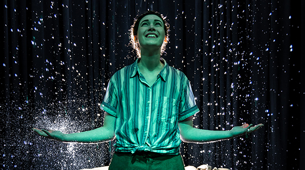 woman standing in rain during theatre production