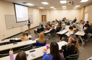 A guest speaks in front of a classroom full of students