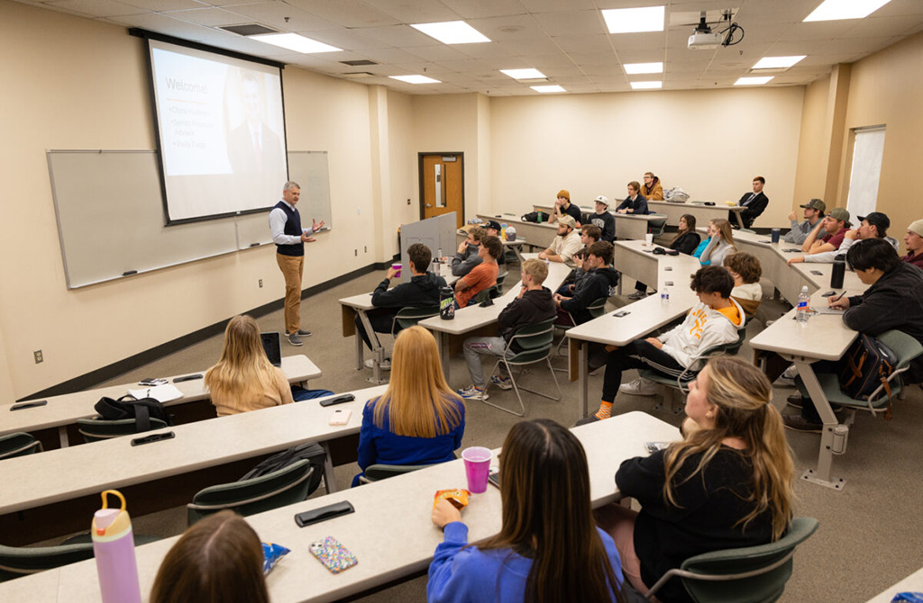 A guest speaks in front of a classroom full of students