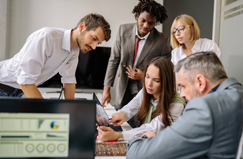 A group looks at a report on a table around a conference table