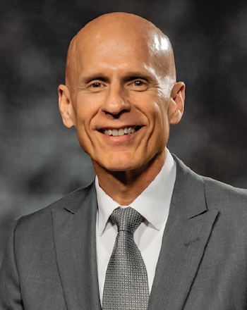 Bob Turner, smiling in a suit