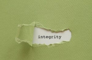 Green paper is pealed back to reveal the word integrity