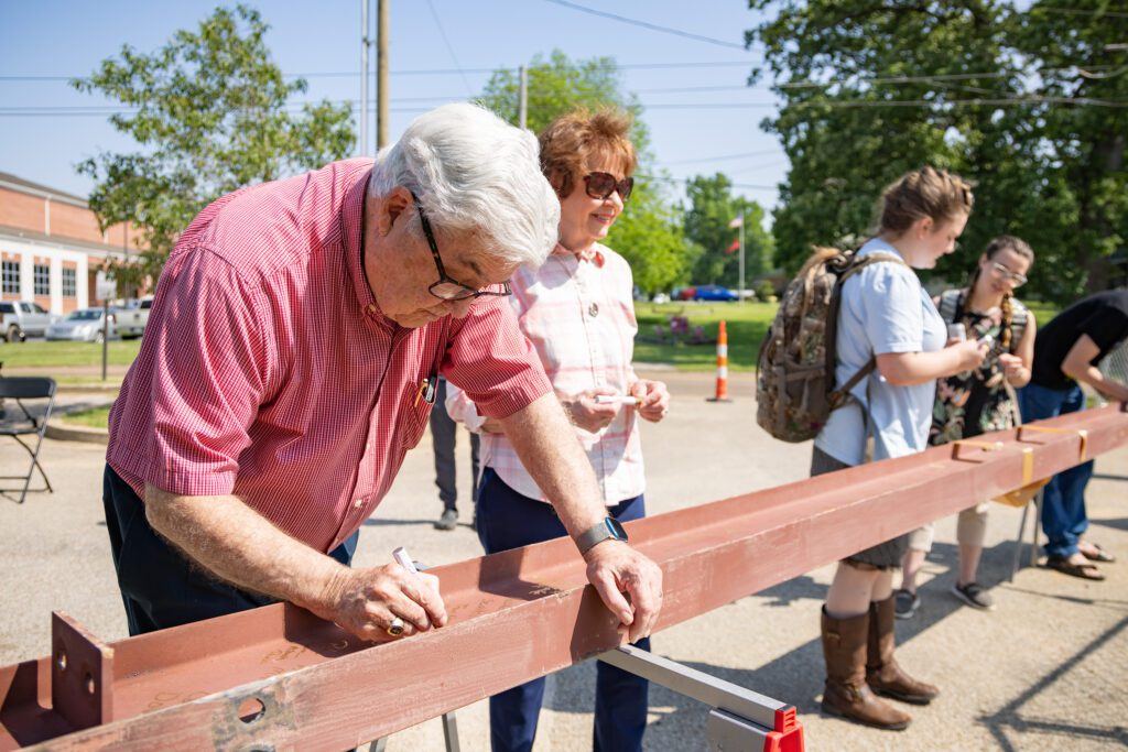 FHU Chancellor Milton Sewell (left) and his wife, Laurel (right), sign the beam during the Topping Out ceremony held Wednesday, May 8, 2024.