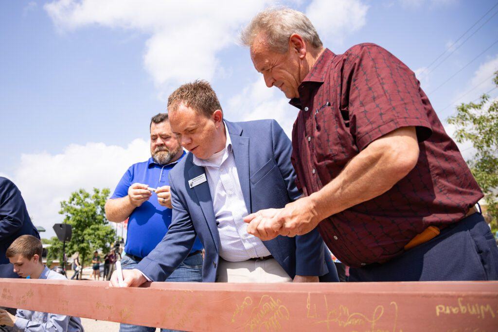 Executive Director of the Henderson/Chester County Chamber of Commerce Blake Hopper (center) and Chester County Mayor Barry Hutcherson (right) sign the beam during the Topping Out ceremony held Wednesday, May 8, 2024.