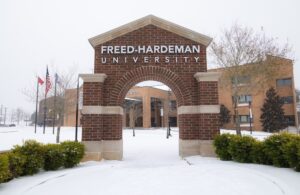 Arch-shaped structure with Freed-Hardeman University printed on it surrounded my snow on the ground