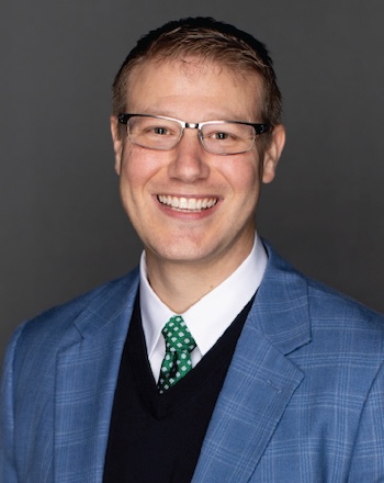 Justin Rogers - a smiling man with glasses