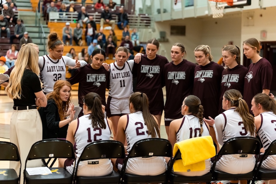The Freed-Hardeman Lady Lions huddle around their coach during a game